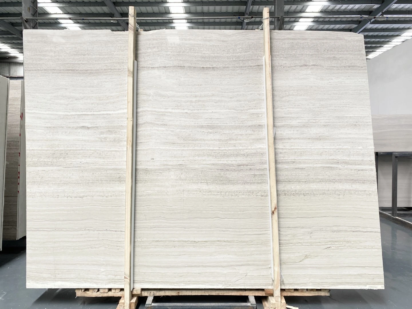 White Wooden Marble slabs featuring soft ivory tones and fine horizontal wood-grain veining White Wooden Marble slabs featuring soft ivory tones and fine horizontal wood-grain veining